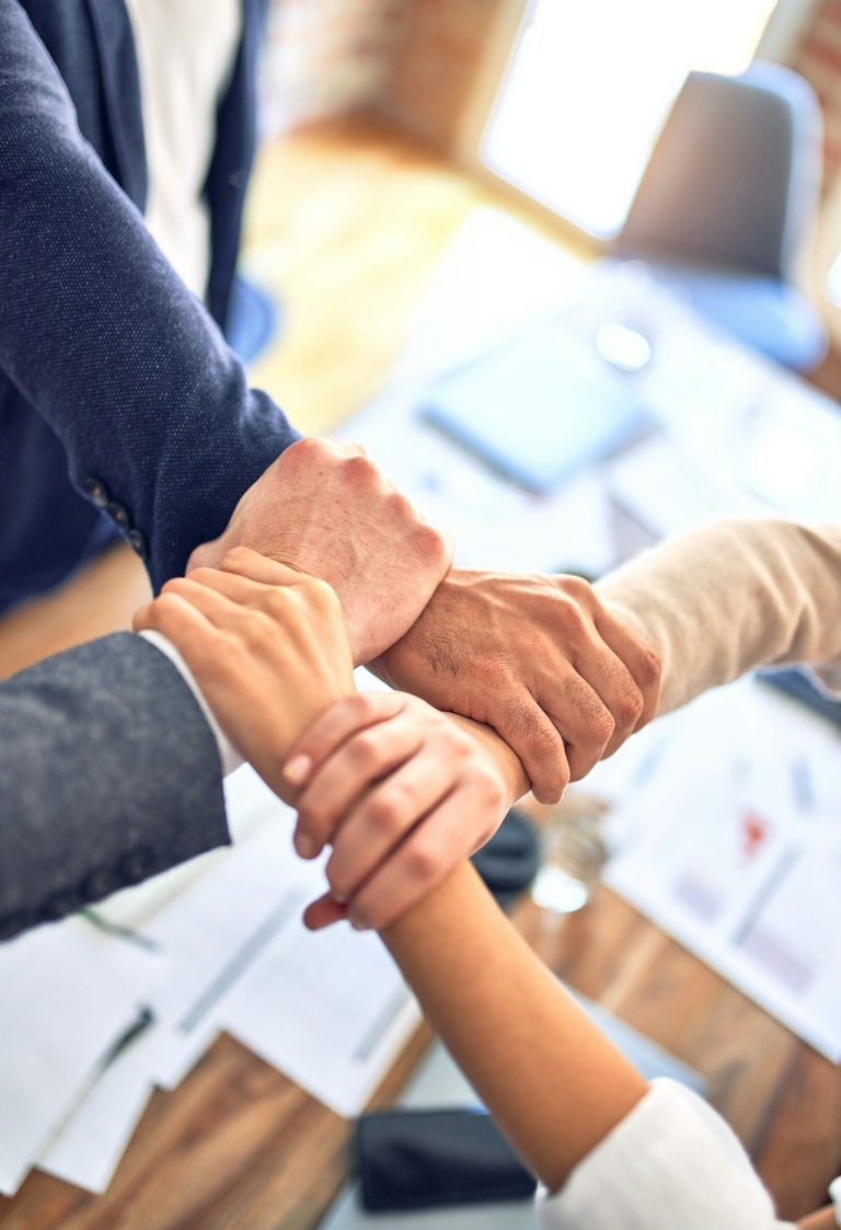 Hände verschiedener Personen, die sich zur Zusammenarbeit verbinden.